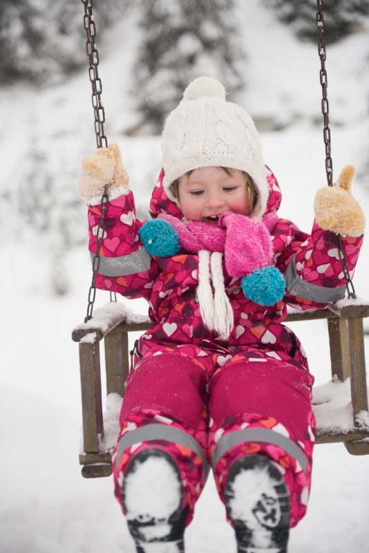 little-girl-at-snowy-winter-day-swing-in-park-P26WNRV-534x800